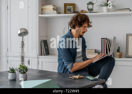 Man working in coworking space, using laptop Stock Photo