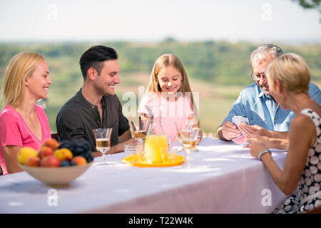 Family playing cards outdoors with children Stock Photo