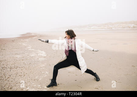 Woman doing yoga exercise on the beach Stock Photo
