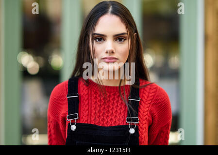 Portrait of fashionable young woman wearing red knit pullover Stock Photo