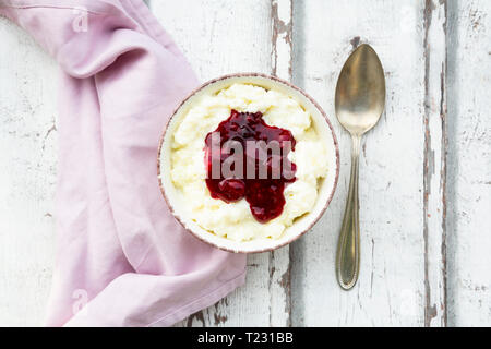 Bowl of rice pudding with cherry and berry groats Stock Photo