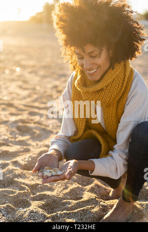 Woman collecting seashells on the beach Stock Photo
