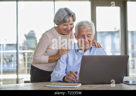 Portrait of smiling senior couple using laptop Stock Photo