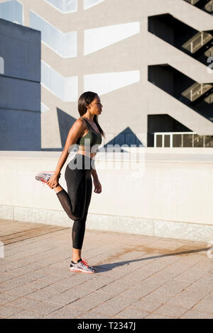 Young woman doing stretching exercise in the city Stock Photo