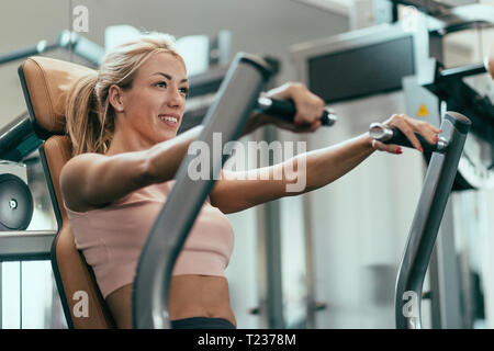 Young Woman Doing Chest Exercise In Fitness Center-102027
