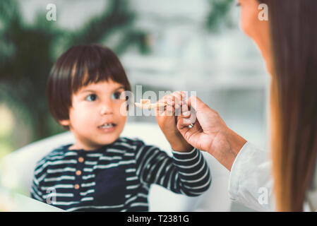 Homeopath giving remedy to child. Stock Photo