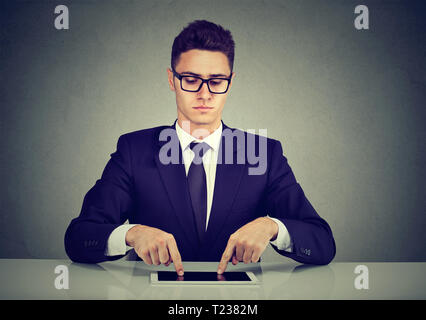 Serious businessman typing with fingers on his tablet computer Stock Photo