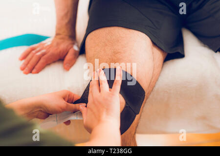 Knee treated with kinesio tex tape therapy Stock Photo - Alamy