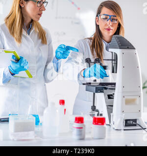 Female students researching samples in laboratory. Stock Photo