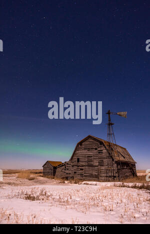 Northern Lights over vintage barn, bins and windmill in Saskatchewan Stock Photo