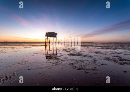 United Kingdom, England, Northumberland, posts marking the pilgrims' way crossing to Lindisfarne with emergency refuge, sunrise Stock Photo