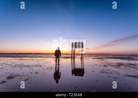 United Kingdom, England, Northumberland, posts marking the pilgrims' way crossing to Lindisfarne with emergency refuge, sunrise Stock Photo