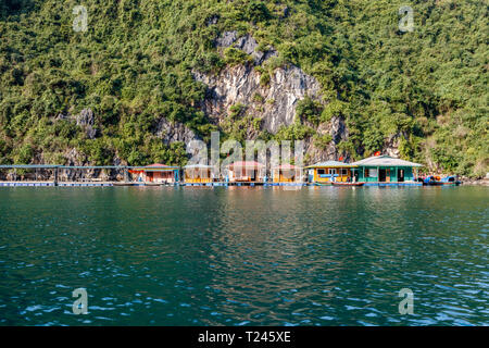 Colorful fishermen houses on the water in Halong Bay (Ha Long Bay) in Northern Vietnam. Day time. Stock Photo