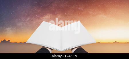 Hand holding opened book, blank pages on colorful starry sky. Concepts of imagination, knowledge, wisdom and education Stock Photo