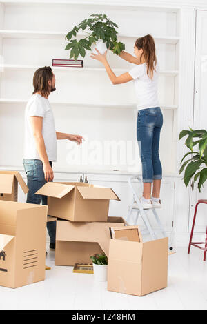Couple unpacking cardboard boxes and furnishing new home Stock Photo