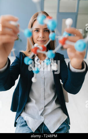 Female scientist studying molecule model Stock Photo