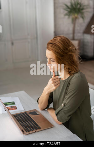 Young woman working in office, using laptop Stock Photo