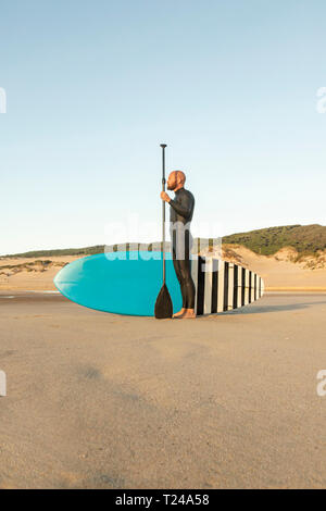 Spain, Andalusia, Tarifa, man with stand up paddle board on the beach Stock Photo