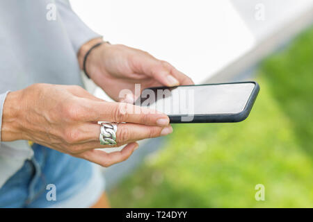 Woman's hands holding smartphone, close-up Stock Photo