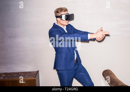 Young man wearing blue suit using Virtual Reality Glasses Stock Photo