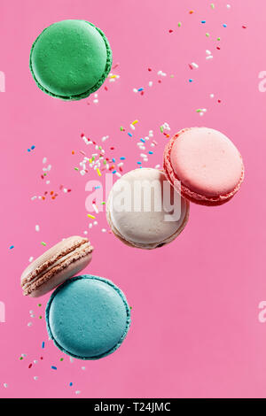Traditional french colorful macarons on pink background. Stock Photo