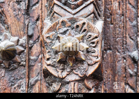 Wooden door with bronze spike showing the carvings in details Stock Photo