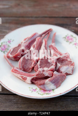 Raw rack of lamb chops on vintage plate Stock Photo
