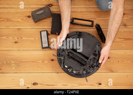 Cleaning the robot vacuum cleaner , robot vacuum cleaner service Stock Photo