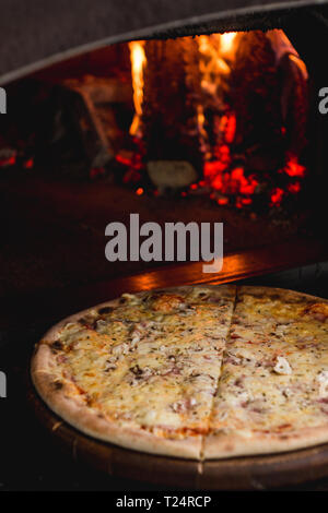 Photo of delicious fresh pizza straight out of the fire place Stock Photo