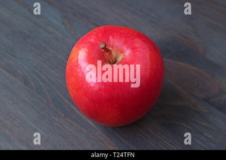 One red apple isolated on dark colored wooden table Stock Photo