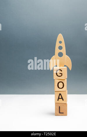 Tower of cubes with the word goal and rocket on top. overcoming obstacles and thinking extraordinarily. Startup and crowdfunding. The purpose of raisi Stock Photo