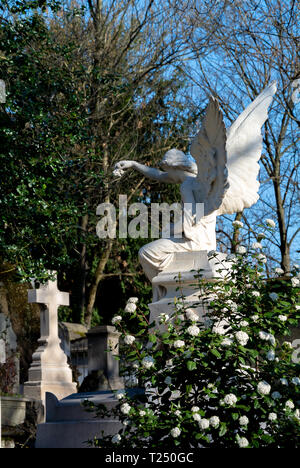 A statue of angel beside cross at pere lachaise cemetery, Paris, France Stock Photo