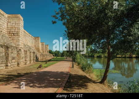 Stone wall from the Alcazaba and pathway next to the Guadiana River at Merida. The city preserves many buildings of ancient Rome in Spain. Stock Photo