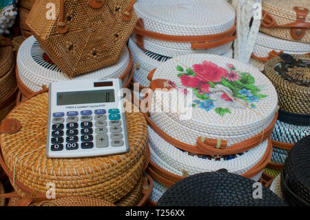 Close up picture of an calculator on a group of brown and white rattan bags displayed at the Ubud Art Market in Bali ,Indonesia Stock Photo