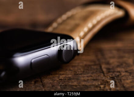 Generic design smartwatch with genuine leather band,strap on wooden background.Shallow DOF Stock Photo