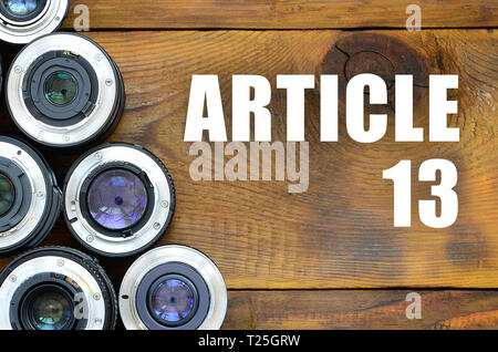 Several photographic lenses and article 13 inscription on wooden background. European copyright directive including article 13 is approved by european Stock Photo