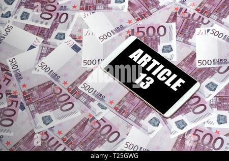 Article 13 inscription on smartphone screen and euro bills. European copyright directive including article 13 is approved by european parliament Stock Photo