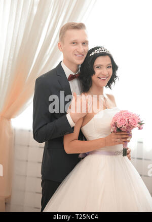 groom and bride standing near the window Stock Photo