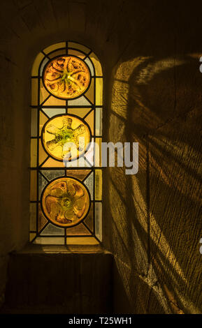 The medieval stained glass of eglise saint-trophime in Arles in the south of France casts a wonderous light over the church walls Stock Photo