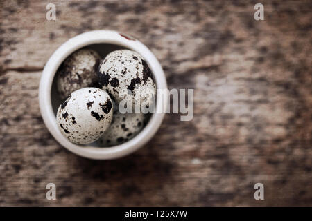 Artwork in retro style, quail eggs, wooden background Stock Photo