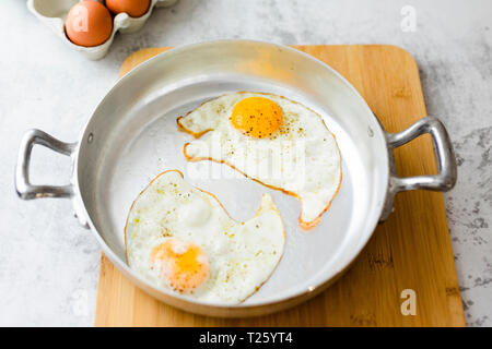 Two fried eggs with pepper in pan Stock Photo