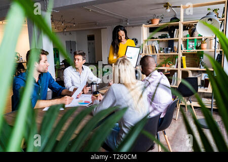 Businesswoman leading a presentation in loft office Stock Photo
