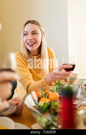 Young woman drinking red wine ata lunch with friends Stock Photo