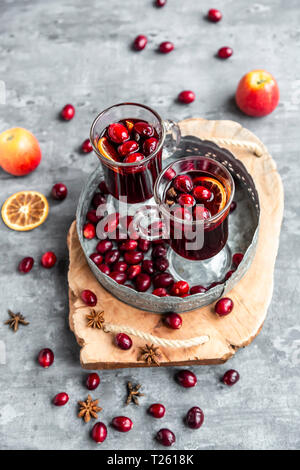 Two glasses of Mulled Wine with cranberries, orange slices and star anise on tray Stock Photo