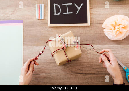 Top view of young woman wrapping a gift in her studio Stock Photo
