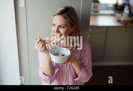 Smiling woman having breakfast in the morning at home Stock Photo