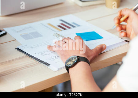 Man working on documents at desk in office Stock Photo