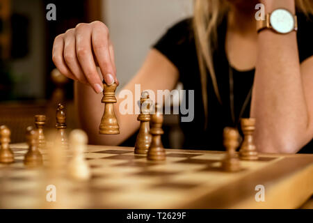 Close-up of a woman's hand moving a chess piece Stock Photo