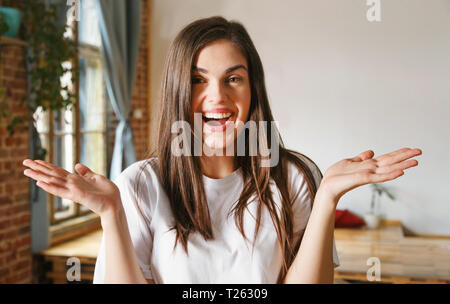 Brunette longhaired happy woman throws up her hands and laughing Stock Photo