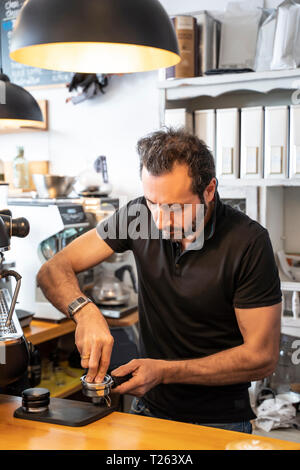 Barista preparing portafilter of coffee machine in a coffee shop Stock Photo